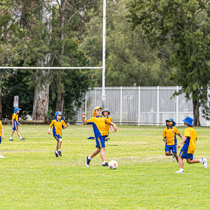 Students playing soccer on the school oval at St Andrews Primary School Marayong